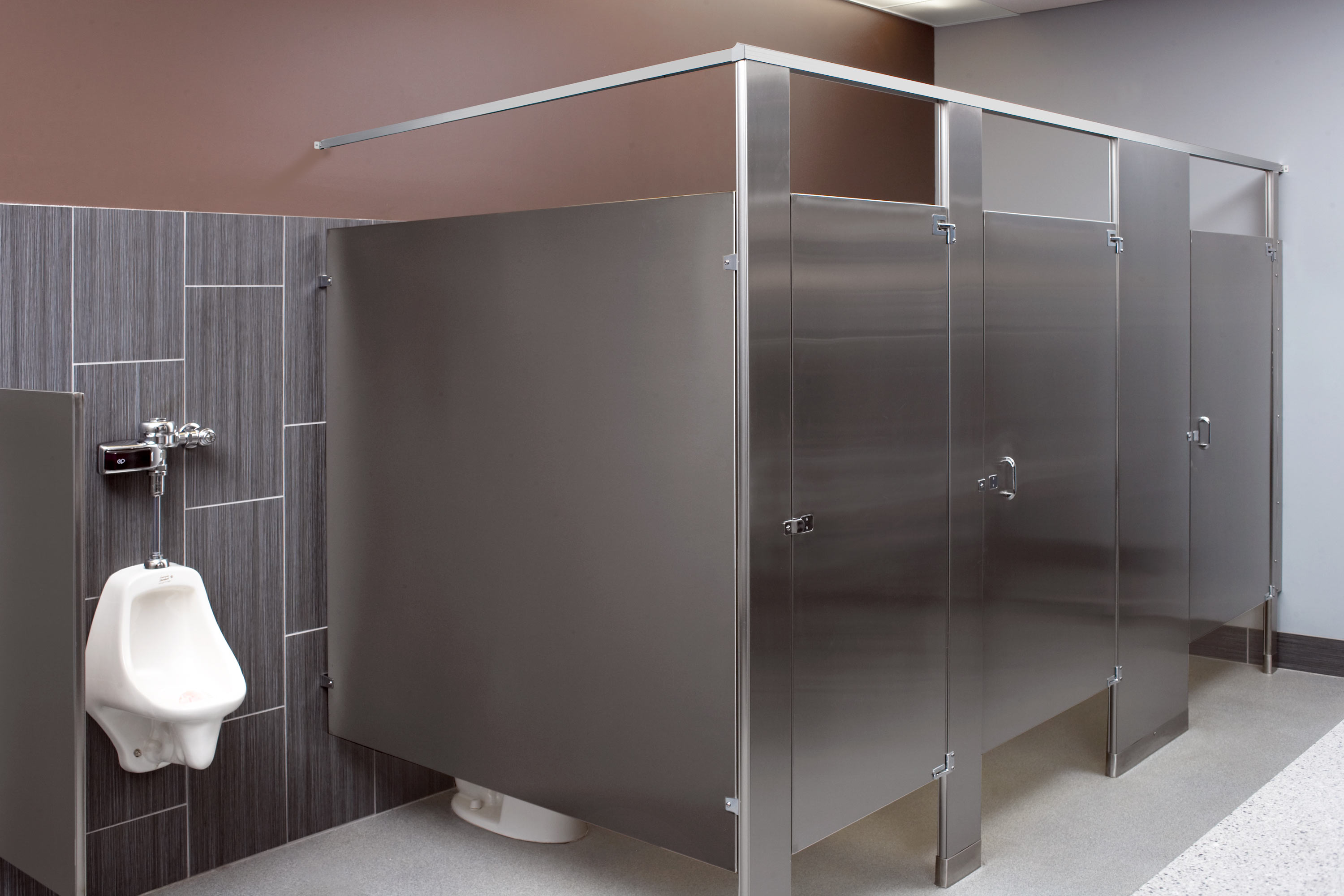Contemporary restroom with stainless steel partitions and a urinal,