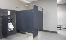 Restroom with a urinal and ADA compliant toilet stall, a locker room is visible through a door