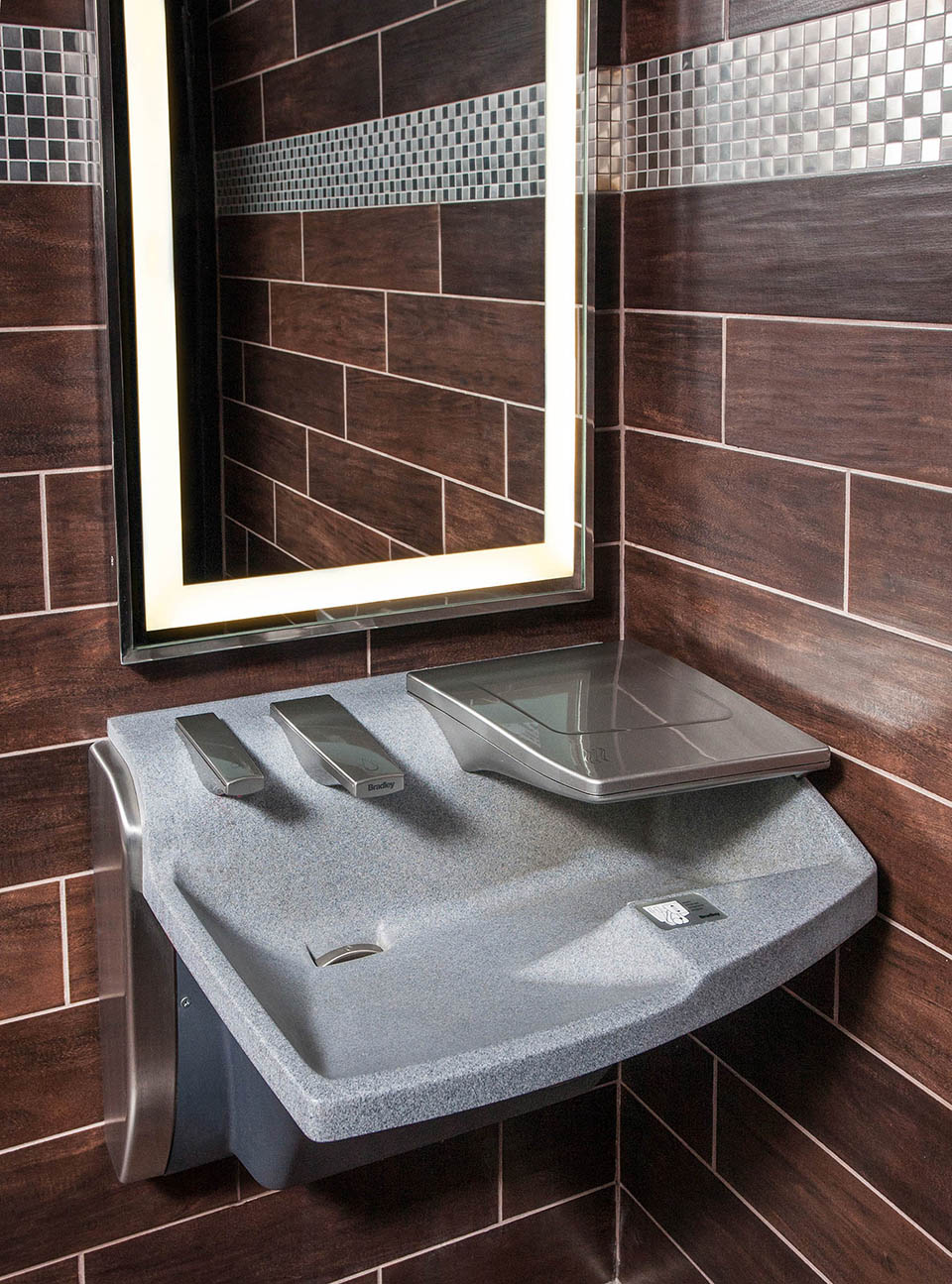 3-in-1 Advocate AV-series sink with co-located soap water and hand drying - shown as single station in a dark restroom